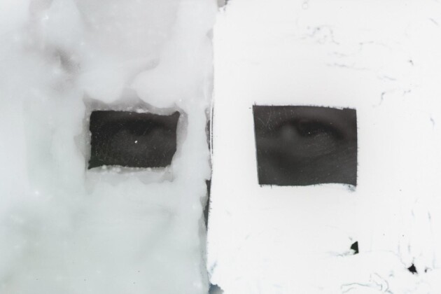 Foto branca com dois recortes de olhos humanos em cinza escuro