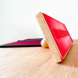 Almofada de tinta vermelha com carimbo escrito "Foi Deus" sob uma mesa de madeira